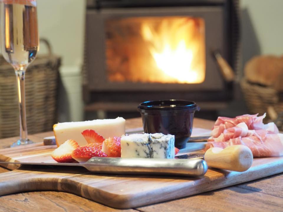 BurrawangLark Cottage的一张木桌,上面放着一盘奶酪和水果