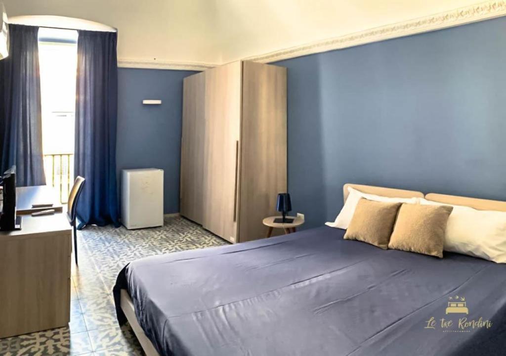 巴列塔Le tre rondini的一间卧室配有一张带蓝色墙壁的大床