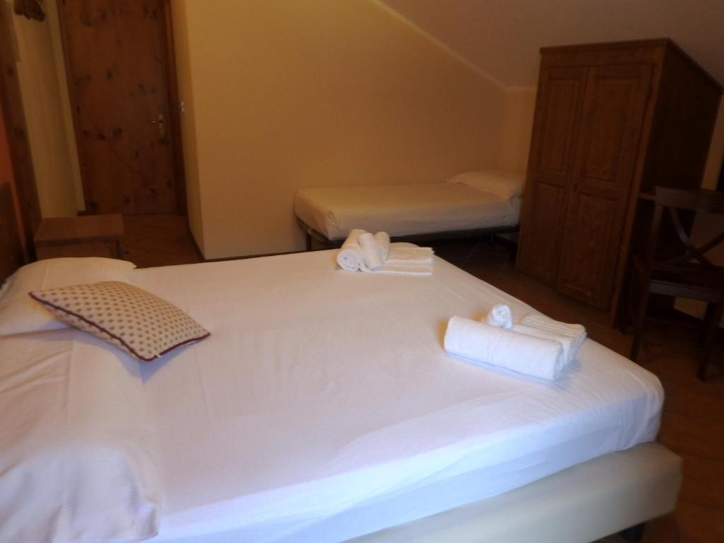 塞斯特雷斯西亚托瑞酒店的一间卧室配有两张床、白色的床单和毛巾。