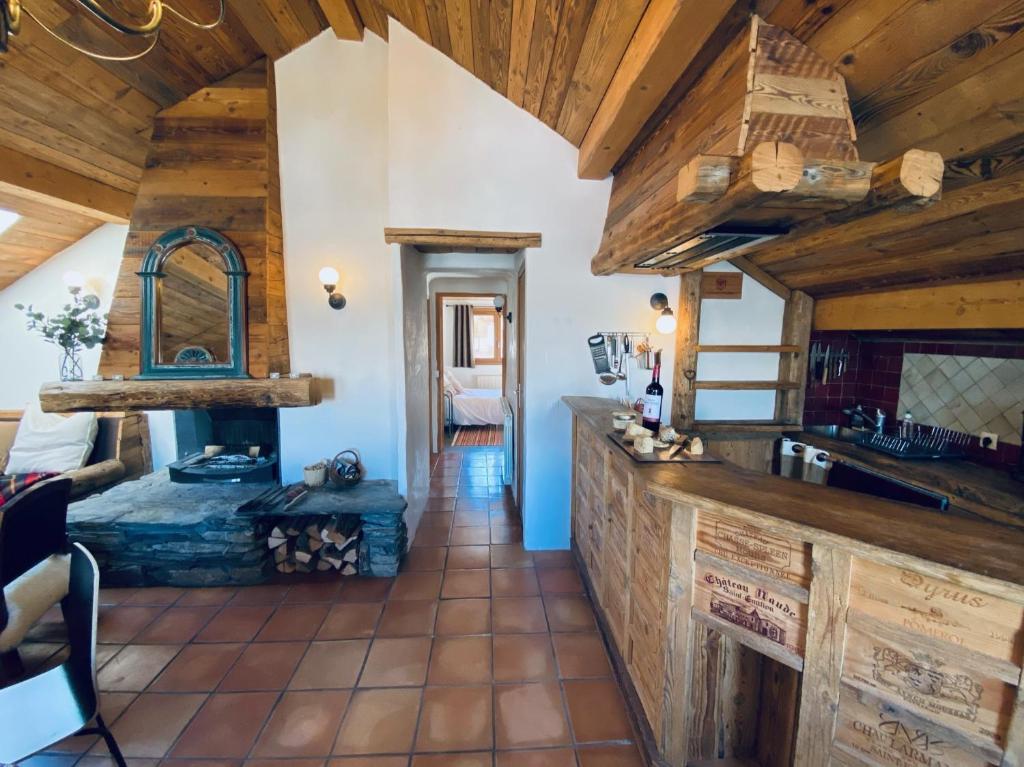 莱斯奥琉斯Charming chalet, 3 rooms, 6 to 8 persons, Meribel, Les Allues的一间带木制天花板的厨房和一间客厅