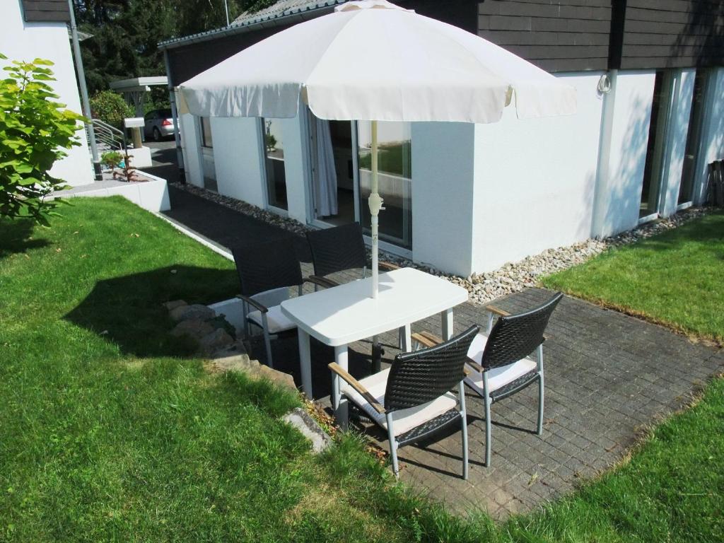 孙登Ferienappartment Allendorf的院子里伞下的桌子和椅子
