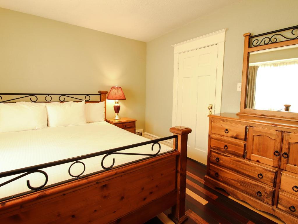 维多利亚詹姆斯湾套房及别墅酒店的一间卧室配有一张床、一个梳妆台和一扇窗户。
