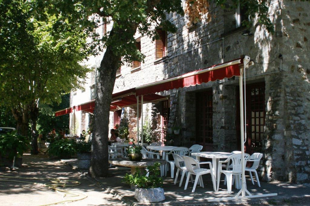 圣皮得迪维纳Hôtel - Pub Le Petit Bosquet的桌子和椅子坐在大楼外