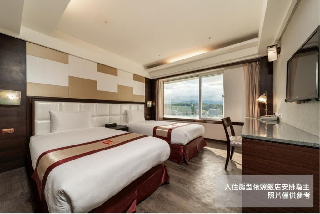 台东鲔鱼家族饭店台东馆的酒店客房设有两张床和电视。