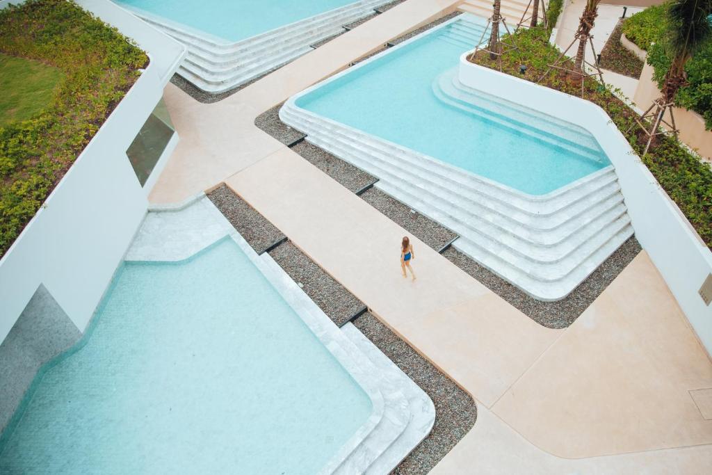 华欣VERSO Hua Hin - a Veranda Collection - SHA Extra Plus的享有度假村游泳池的顶部景致