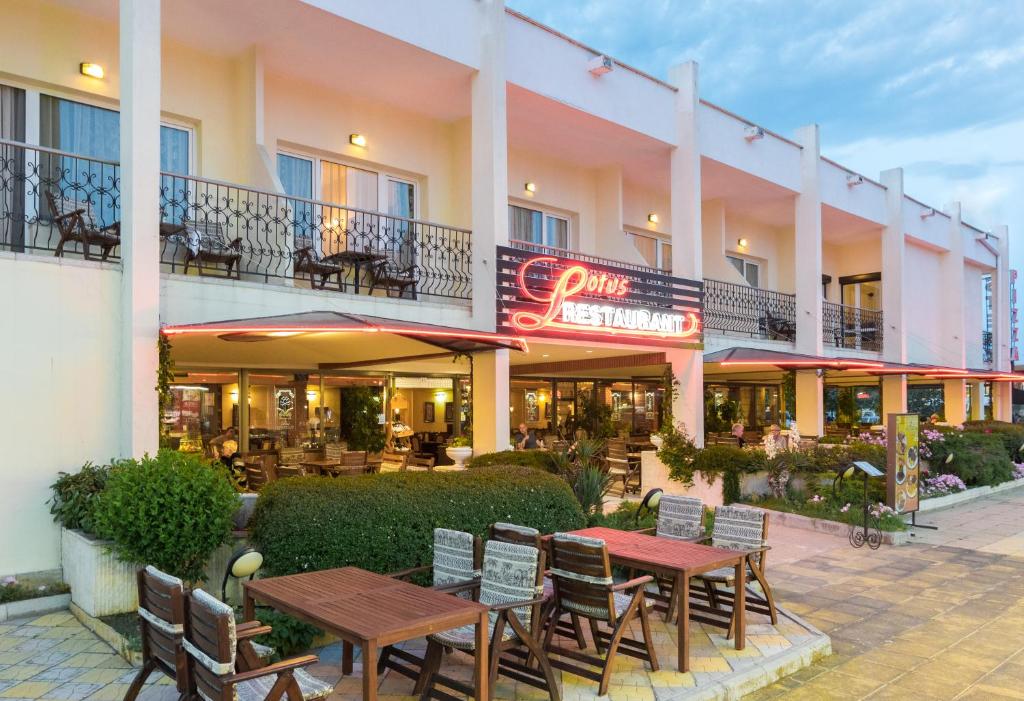 阳光海滩Lotus Family Hotel - Free Parking的外面设有桌椅的酒店