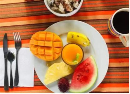 南威HOMELAND SWAHILI LODGE Nungwi Backpacker Apartments BUDGET的桌上一盘早餐食品和水果
