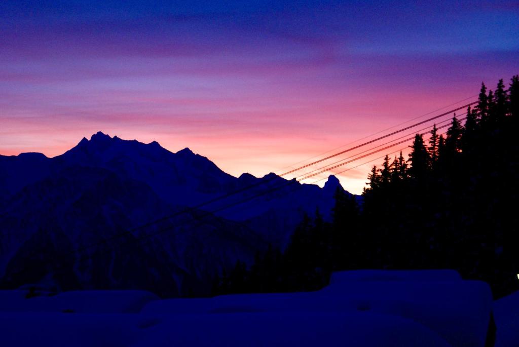 贝特默阿尔卑Perle des Alpes, Bettmeralp, Switzerland的山 ⁇ 上方的日落