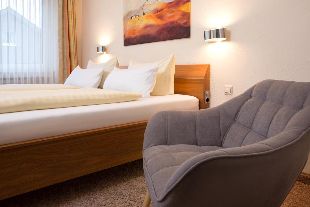 利普施塔特Parkhotel Lippstadt的配有一张床和一把椅子的酒店客房