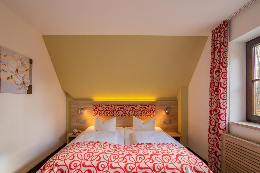 萨克森自由州诺伊斯塔滕Berggasthof Götzinger Höhe的一间卧室配有一张带红色床罩的大床