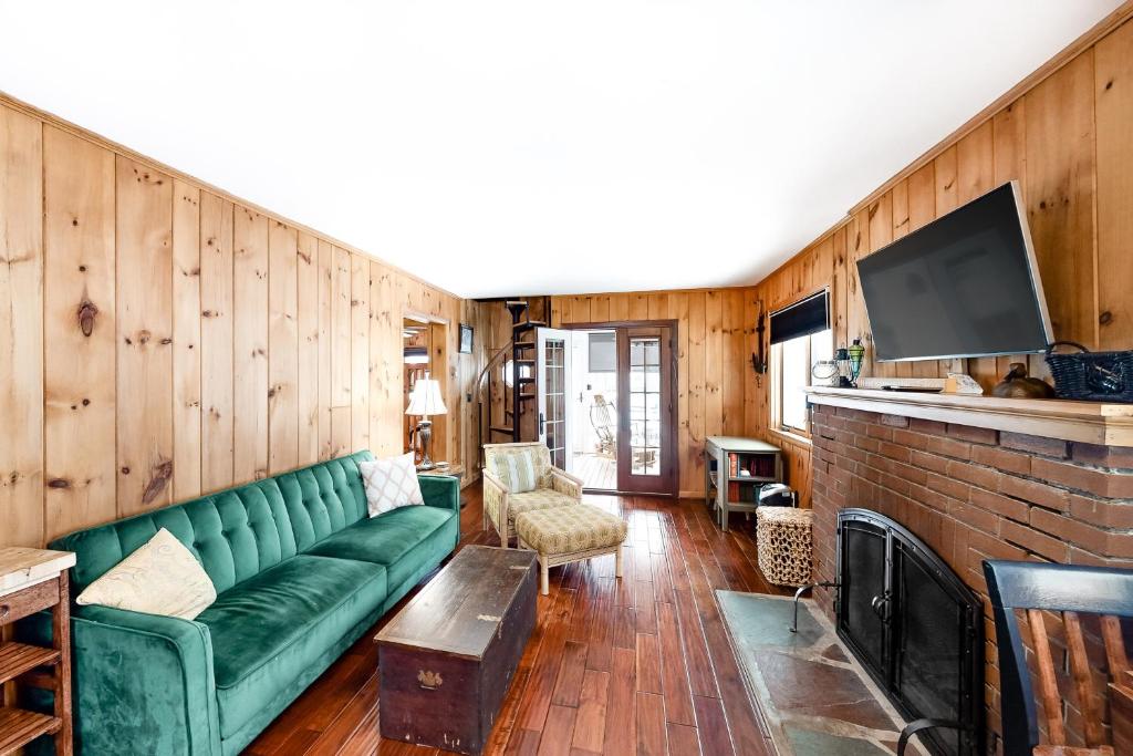 乔治湖Takundewide Retreat的客厅设有绿色沙发和壁炉