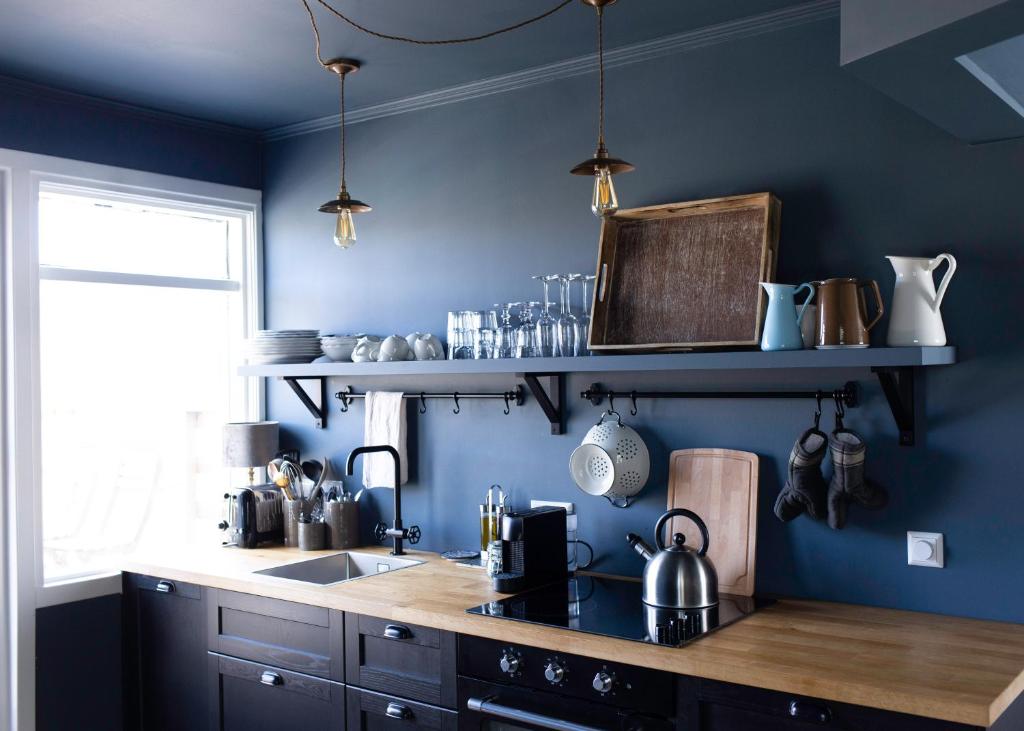 惠拉盖尔济INNI - Boutique apartments的厨房设有蓝色的墙壁和木制台面