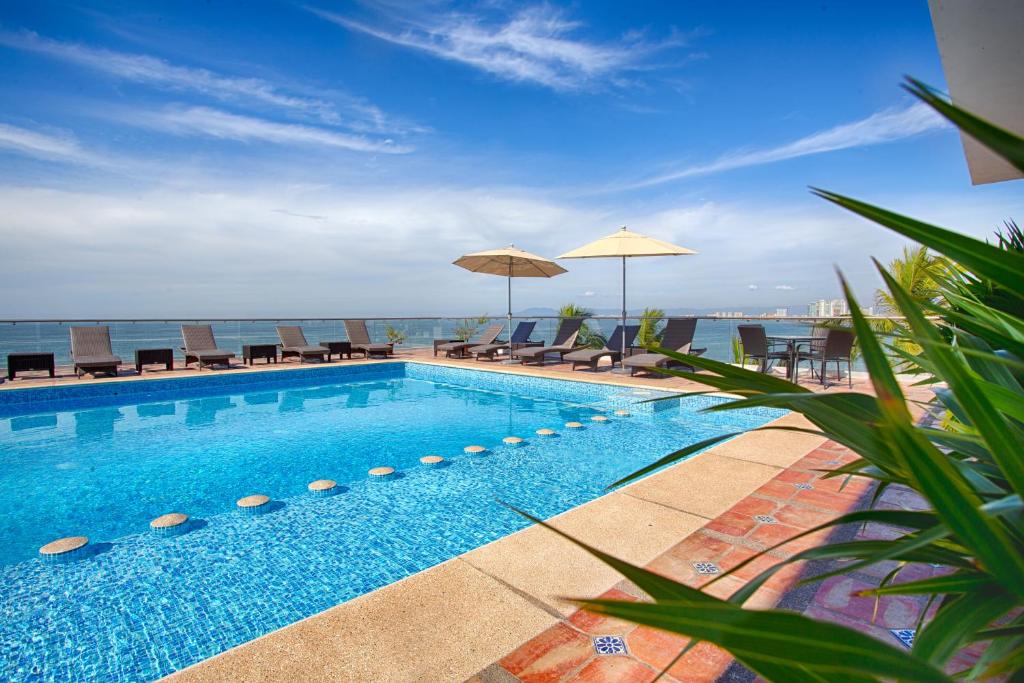巴亚尔塔港The Paramar Beachfront Boutique Hotel With Breakfast Included - Downtown Malecon的一个带椅子和遮阳伞的游泳池