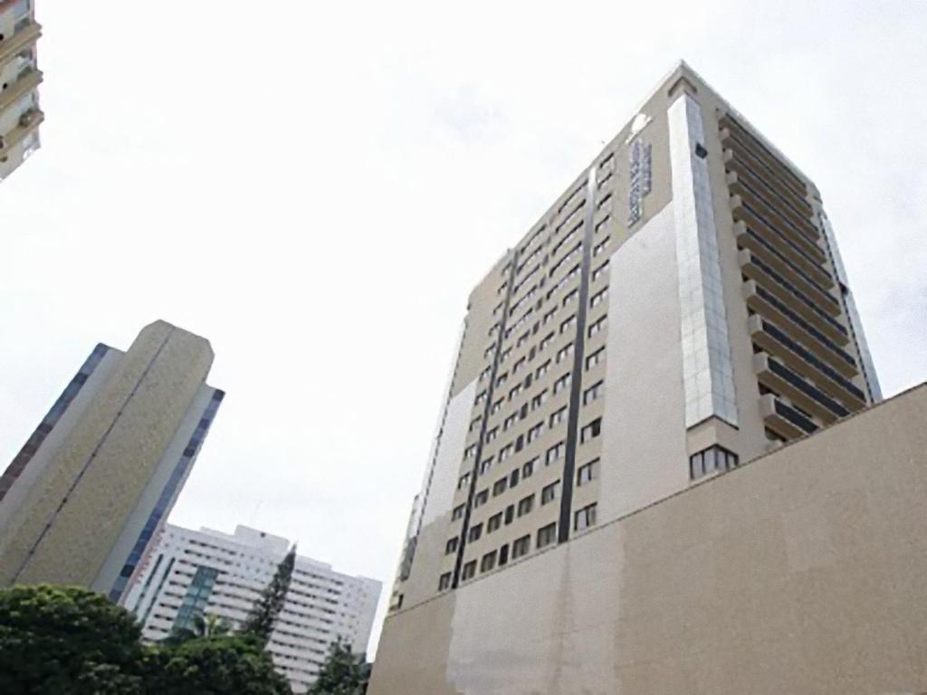 巴西利亚Duplex Apto Setor Hoteleiro Norte com serviço diário de limpeza的一座高大的白色建筑,上面有一座塔