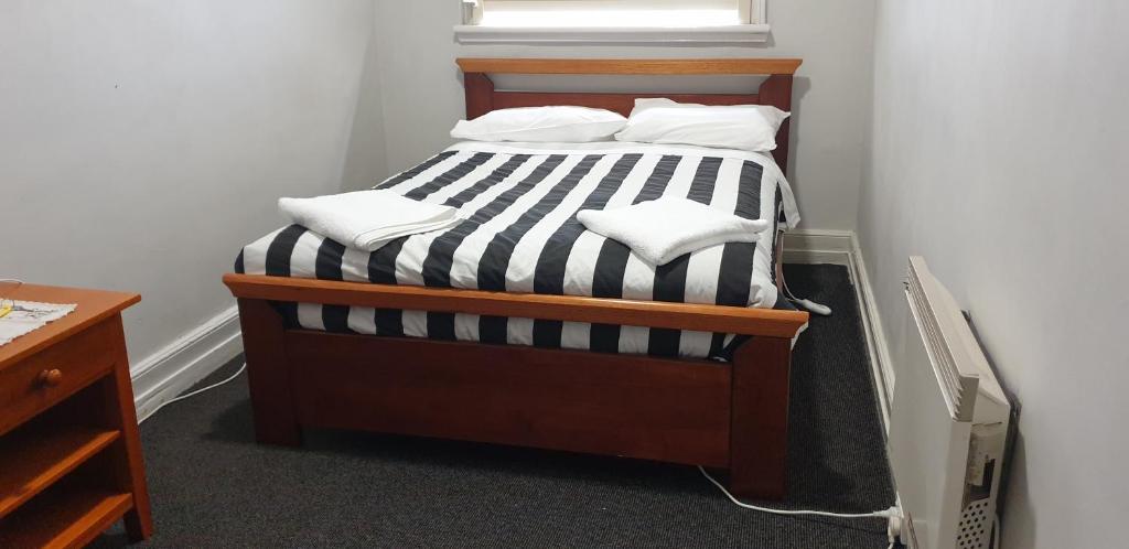 巴拉腊特The Eastern Hotel - Adults Only的一张带黑色和白色条纹床单和枕头的床