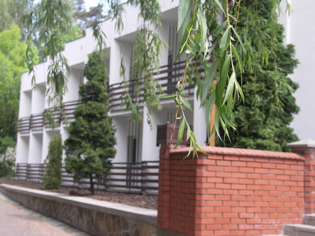 波兹南Strzeszynek - wypoczynek的白色的建筑,有砖墙和树木