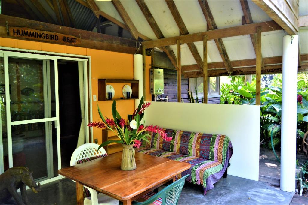 圣伊格纳西奥Hummingbird Rest a fully equipped cabana in subtropic garden的天井上的沙发和鲜花桌