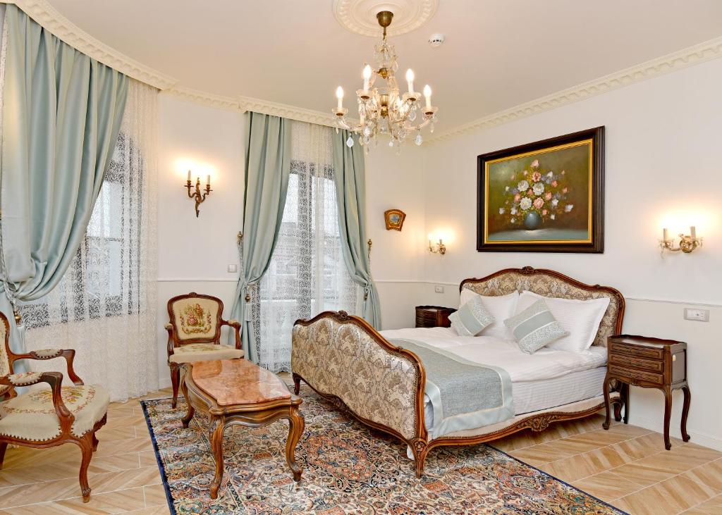 瓦尔纳Royal Hotel的一间卧室配有一张床、椅子和吊灯