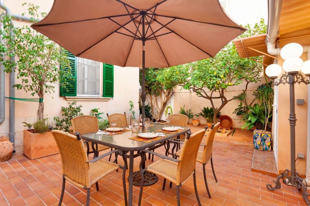 马略卡岛帕尔马Can Duran的庭院配有桌椅和遮阳伞。