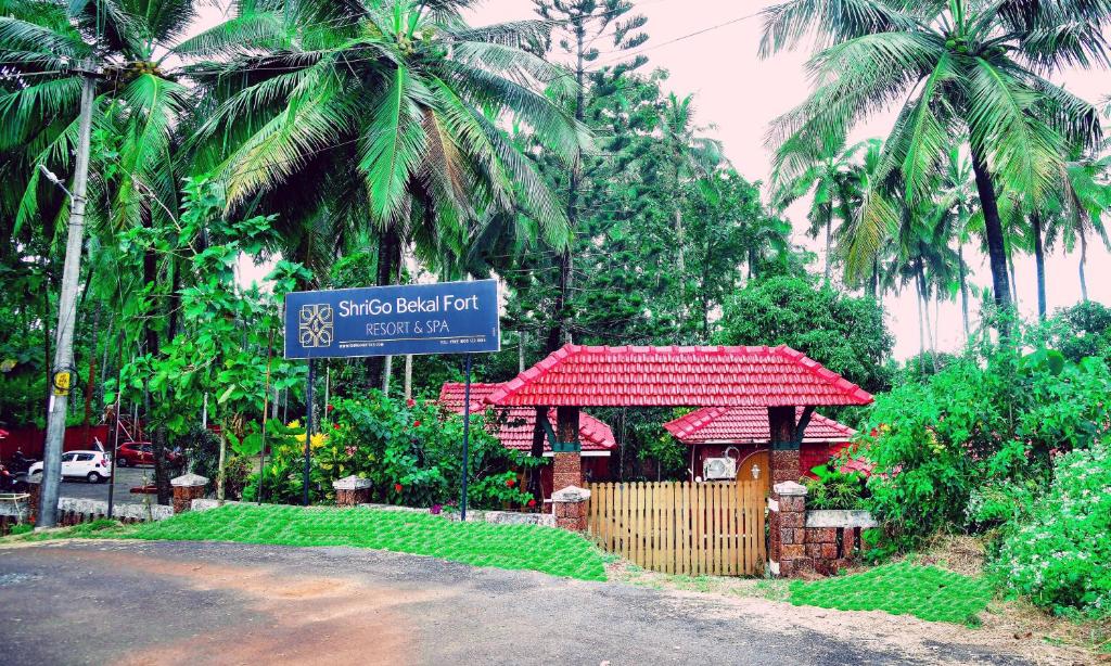 贝格尔ShriGo Bekal Fort Resort & Spa的棕榈树建筑前的街道标志