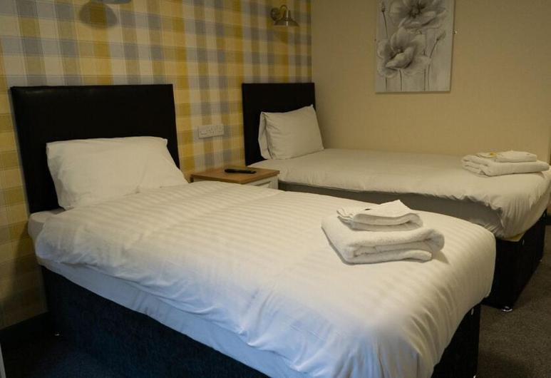 伯明翰The Aston Inn的两张位于酒店客房的床,配有毛巾