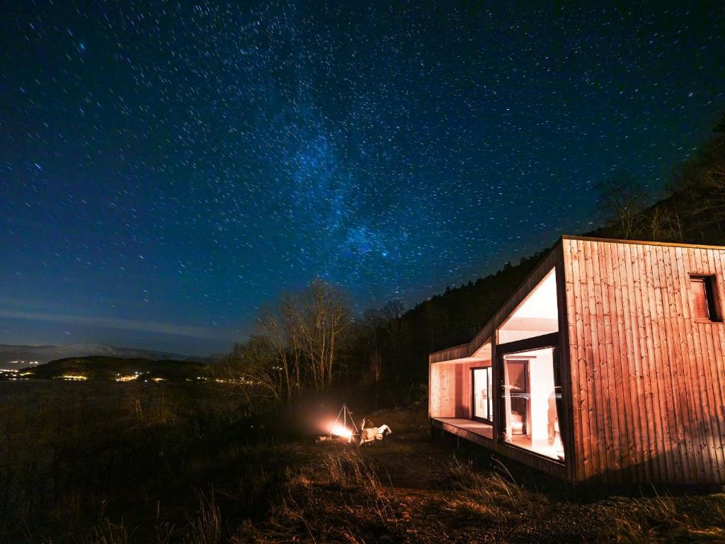 SamlanesFunkis-cabin in Herand with fantastic fjordview的小屋,晚上在田野里 ⁇ 火
