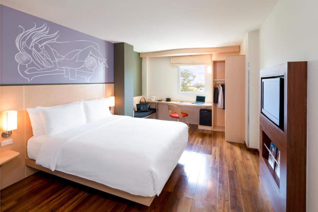 万象宜必思万象南富酒店的卧室配有一张白色大床和一张书桌