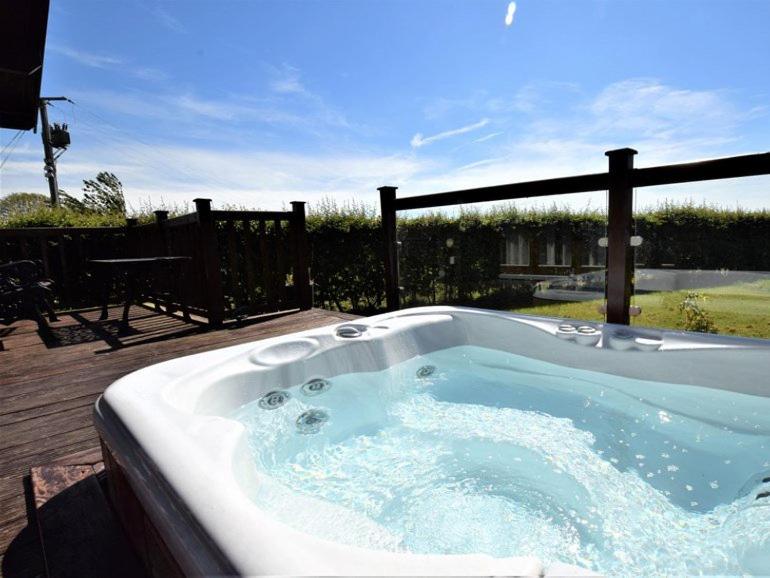 卡莱尔Pheasant Lodge Scottish Borders的甲板上的一个按摩浴缸