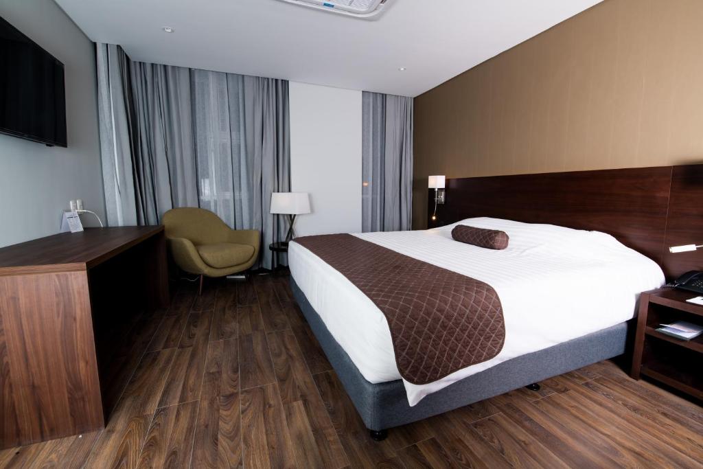 拉巴斯雷诺瓦酒店的配有一张床和一张书桌的酒店客房
