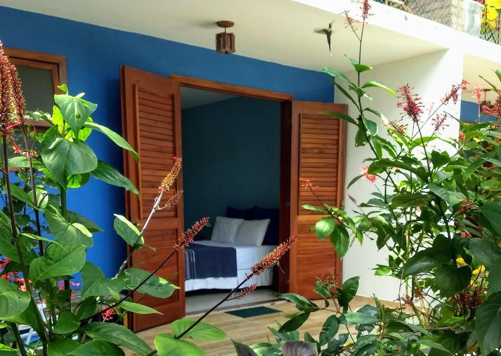 伦索伊斯Pousada Casa Viva a Vida的一间设有蓝色墙壁和一张床的客房