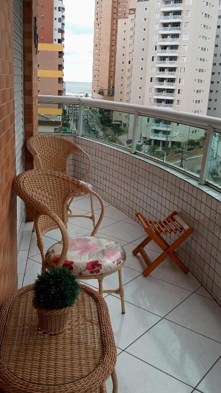 圣保罗Apartamento praia Grande的阳台配有2把椅子和桌子