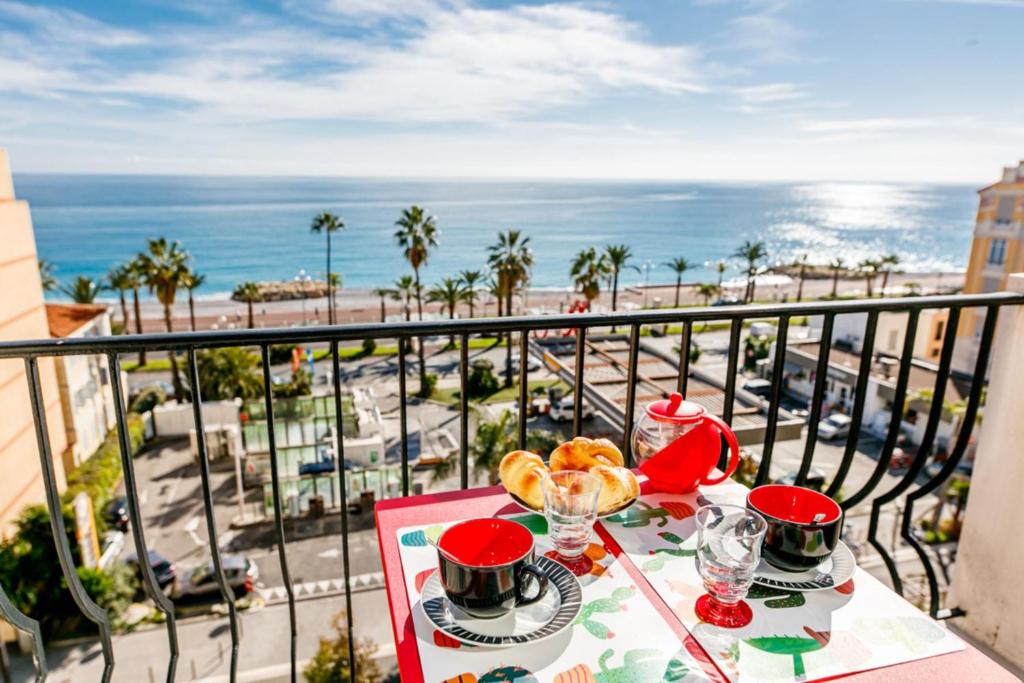 尼斯TAMARIS AP4206 By Riviera Holiday Homes的一张带食物的桌子,享有海景
