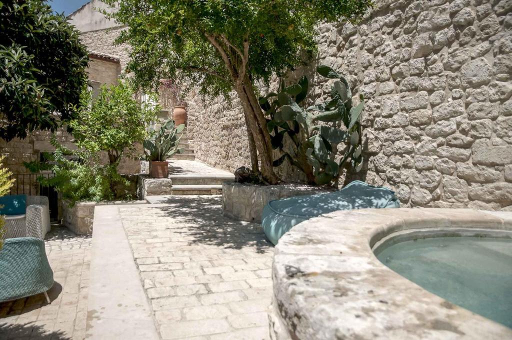 莫迪卡Anime a Sud - Residenza Hortus的一座石头建筑,在院子里设有游泳池