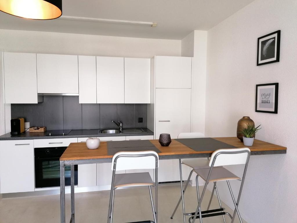 卢塞恩Easy-Living Lucerne City Apartments 1的厨房配有白色橱柜和桌椅
