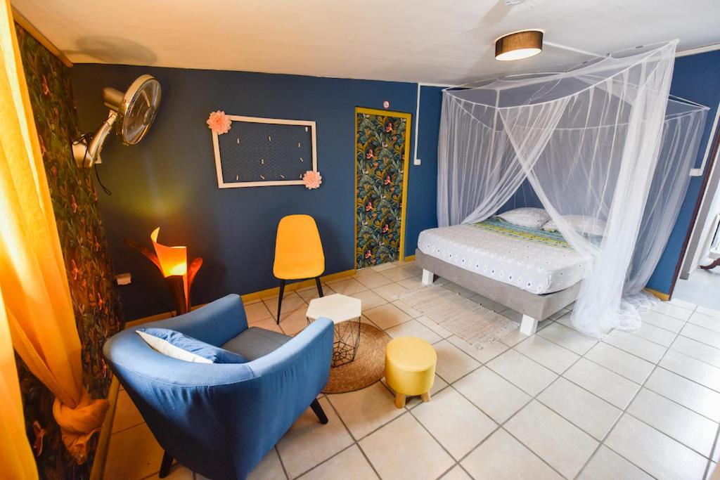 圣玛丽La Maison des Oeillets Aéroport Roland Garros的一间带一张床和椅子的卧室