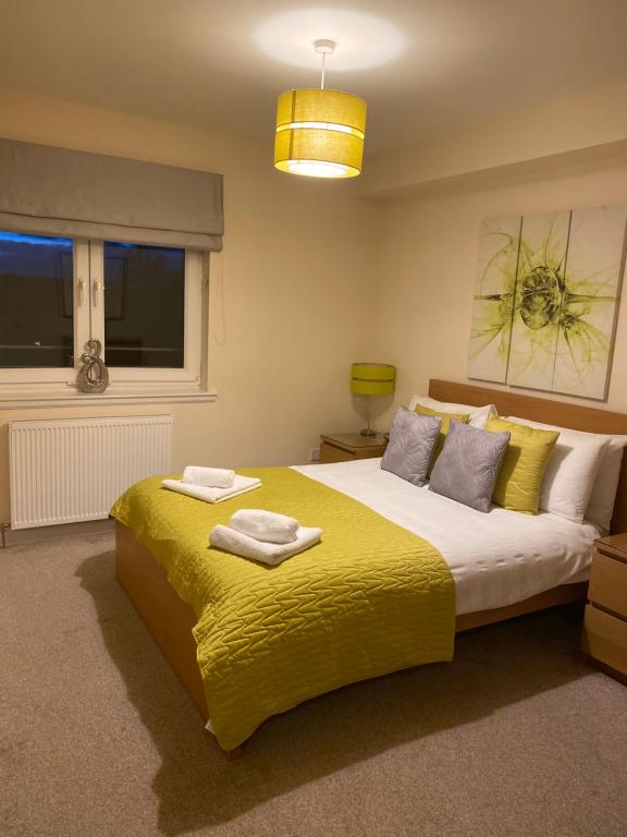 阿伯丁AB11公寓 - 波特兰街的一间卧室配有一张带黄色毯子的大床