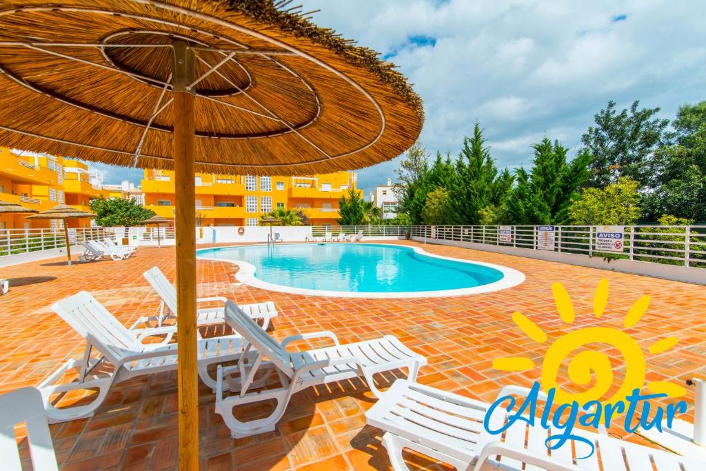 卡巴纳斯·德·塔维拉Royal Cabanas Golf by Algartur的一个带椅子和遮阳伞的游泳池