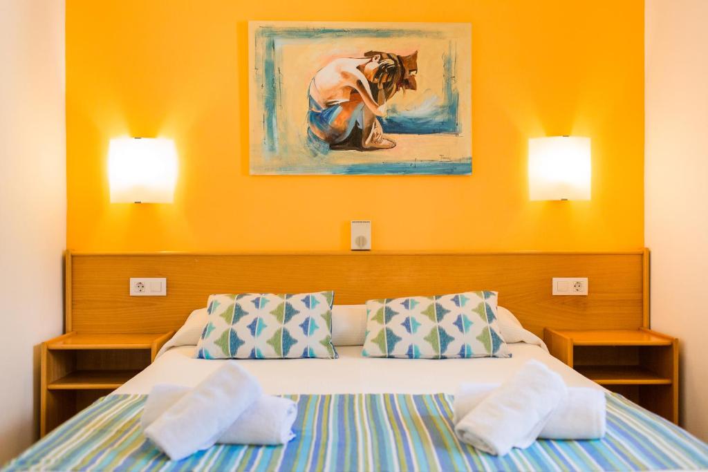 卡拉布兰卡Sagitario Vista Playa I Apartamentos的一间卧室配有带2个枕头的床