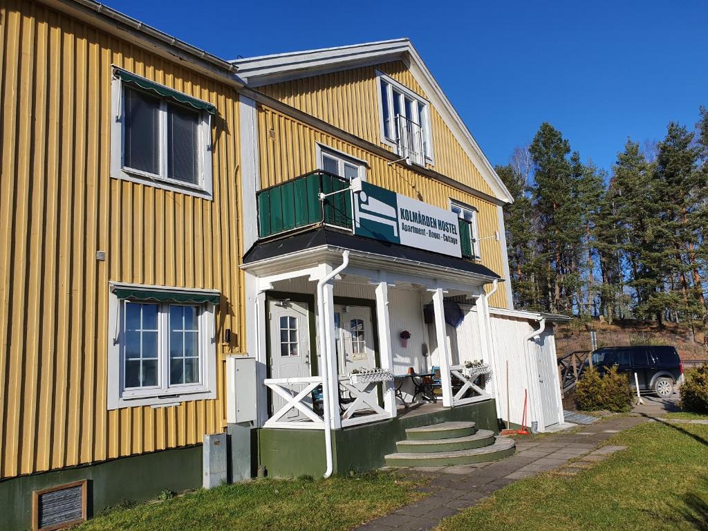 StavsjoKolmården Apartments & Cottages的黄色的房屋设有门廊和阳台