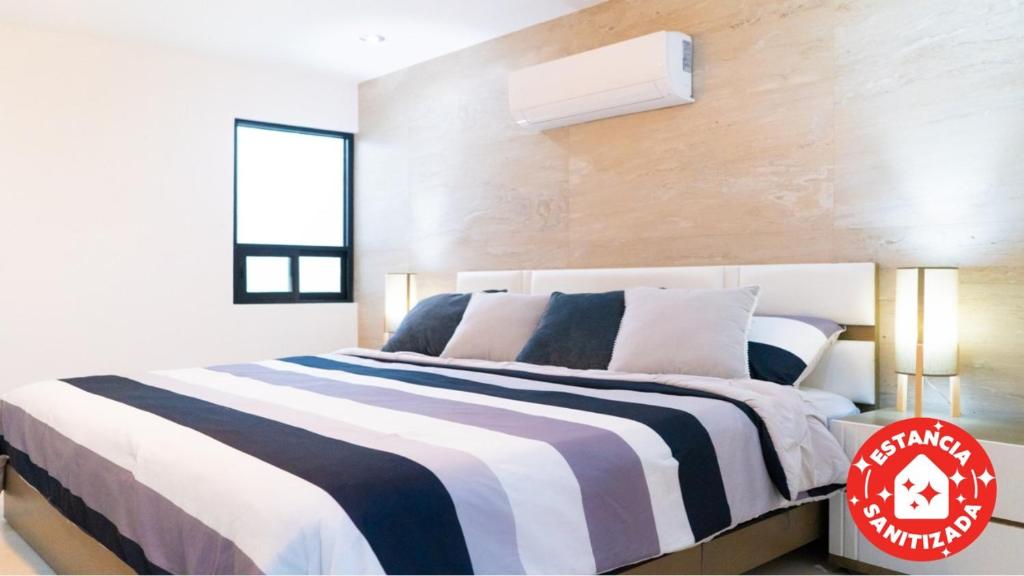 蒙特雷ECONOSUITES FUNDIDORA的一间卧室配有一张带黑白条纹毯子的床