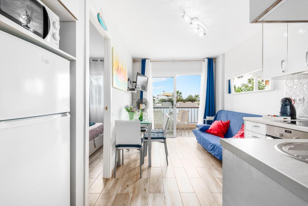 美洲海滩Apartamento El Dorado, Wi-Fi y aparcamiento gratuito的厨房以及带蓝色沙发的客厅。