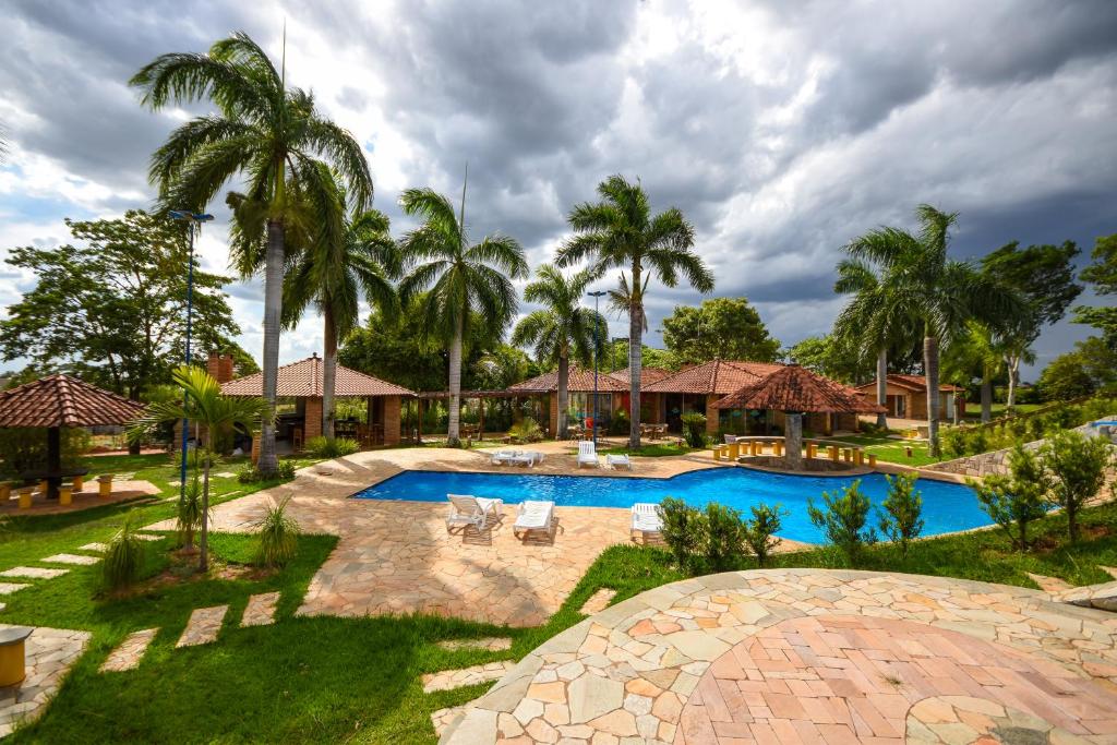 AdamantinaHOTEL ABAPORU的一个带游泳池和棕榈树的度假村