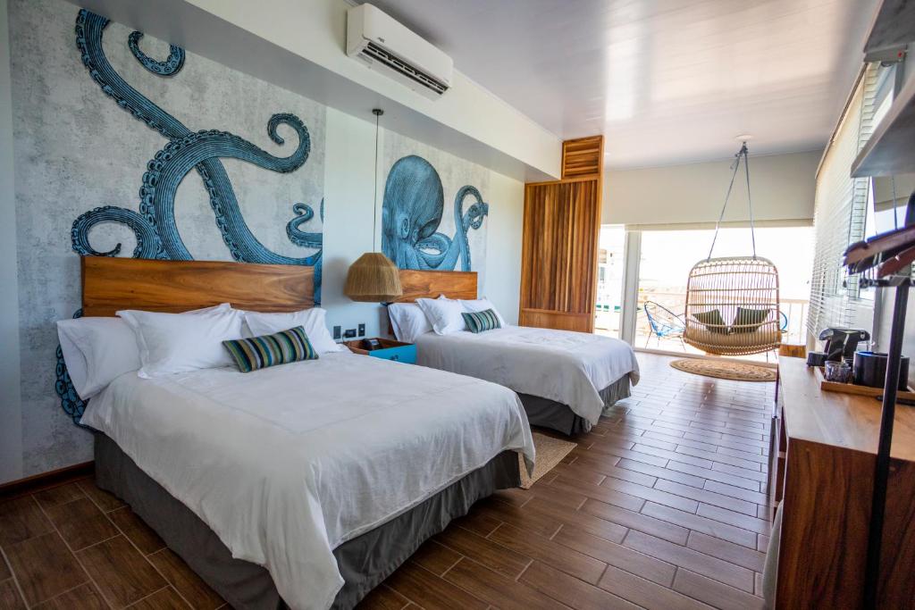 戈尔菲托Amaka Ocean Living Lodge的酒店客房设有两张床和大窗户。