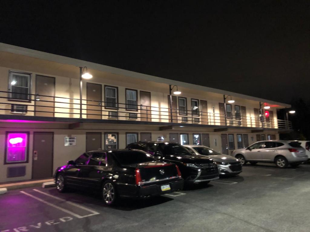 米堤亚Trolley Stop Motel, Media ,Near PHL Airport PA的停在大楼前停车场的一群汽车