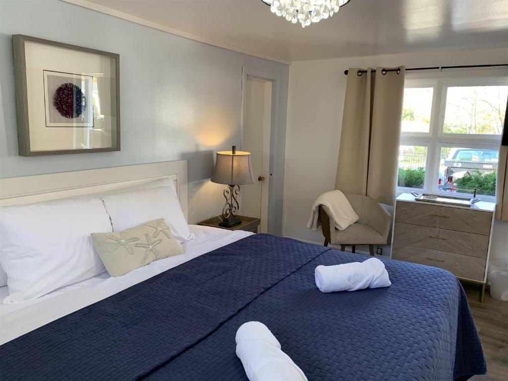 罗克波特Starlight Lodge at Rockport Harbor的一间卧室配有一张带蓝色毯子的大床