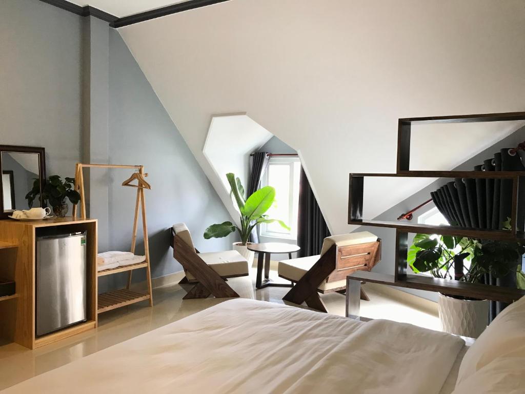 大叻CozyNook Boutique Apartments - 3 thang 2 Street的卧室配有一张床和一张桌子及椅子