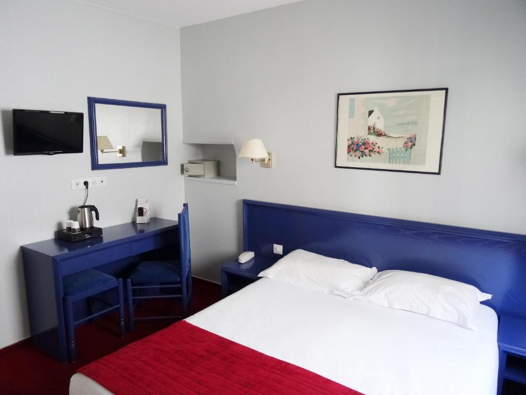 巴黎普莱公寓的一间卧室配有一张蓝色的床和一张带镜子的书桌