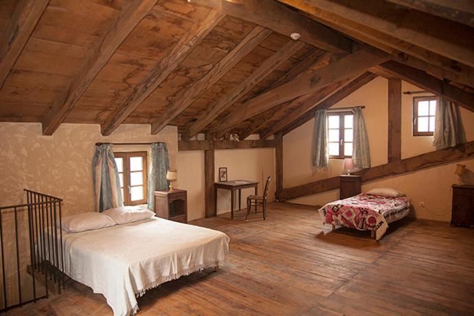 弗洛拉克La ferme des Cévennes的阁楼上一间卧室配有床和书桌