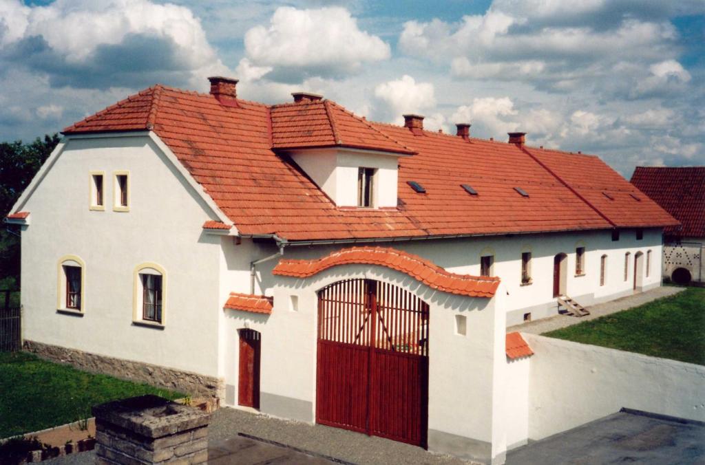 MalšiceBlažkův Statek的白色房子,有红色屋顶,有门