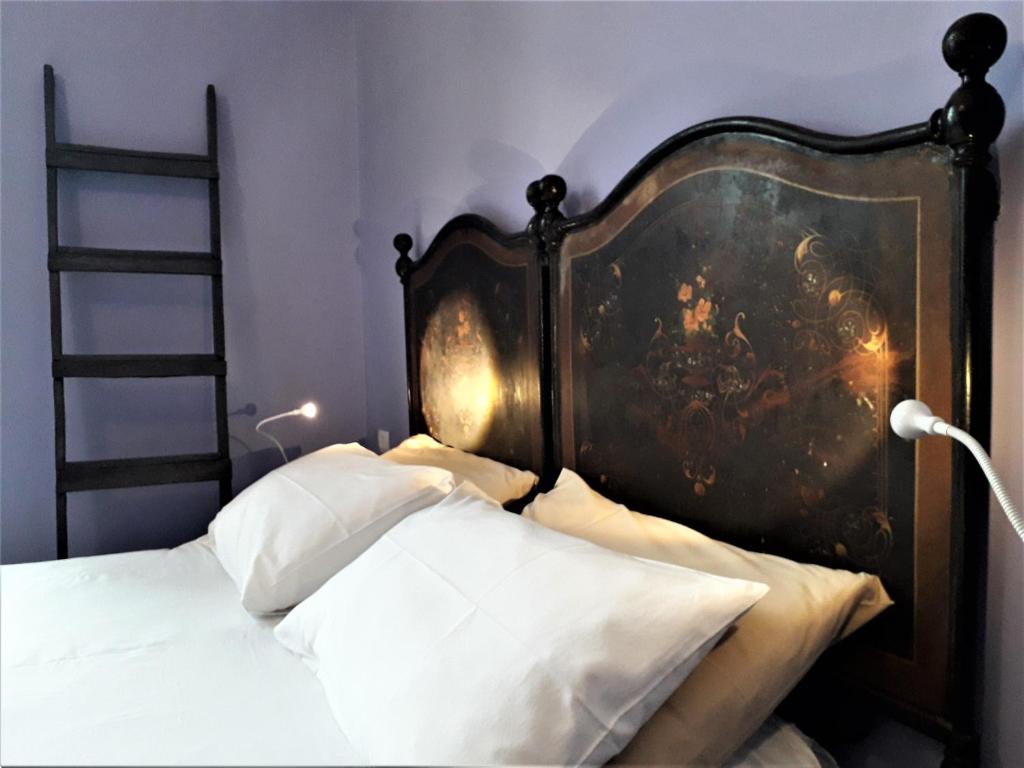 布林迪西I Templari B&B self-contained的一张带木制床头板的床和墙上的绘画